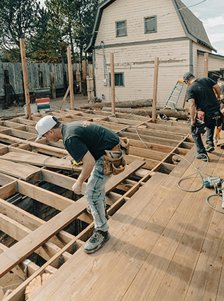 Charpentier posant un solivage de terrasse bois