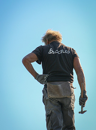 Couvreur travaillant sur une toiture avec marteau