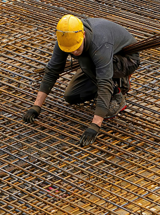 Ferrailleur assemblant des armatures en acier