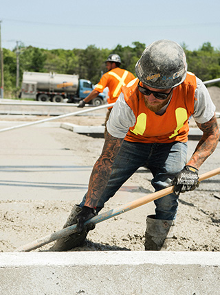 Ma&ccedil;on coulant une dalle b&eacute;ton sur chantier