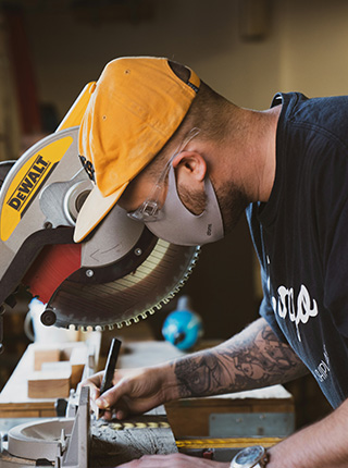 Menuisier d&eacute;coupant du bois &agrave; la scie &agrave; onglet