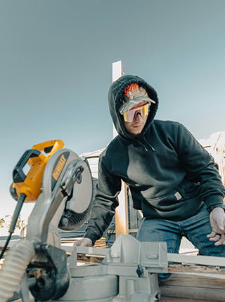 Menuisier utilisant une scie circulaire sur chantier ext&eacute;rieur