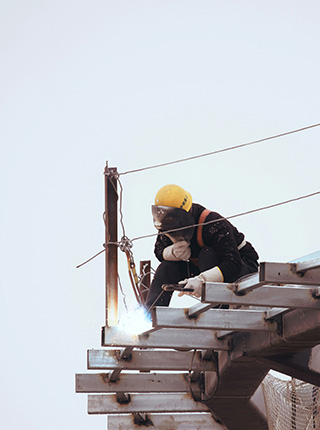 Soudeur assemblant une structure m&eacute;tallique en hauteur